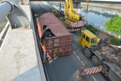 Thùng container rơi từ trên cầu xuống đất, rách bươm