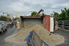Xe tải chở cát lật nhào trên cầu vượt